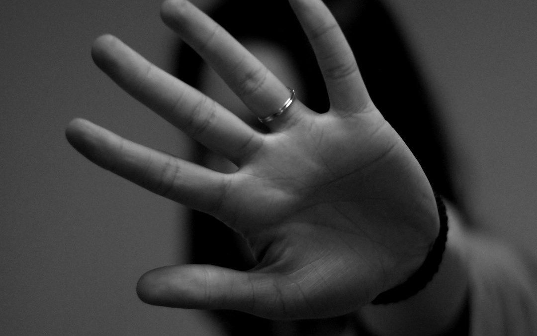 woman showing left hand with wedding band