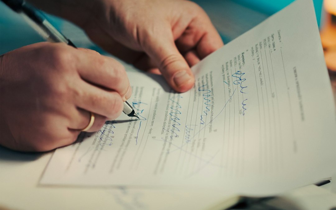 Man signing a document with a pen